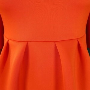 Detail of orange knit dress showing high-quality waist seams and pleated stitching fabric