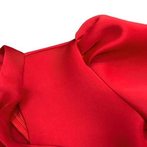 Detailed close-up of square neckline and hidden side zipper on red satin dress