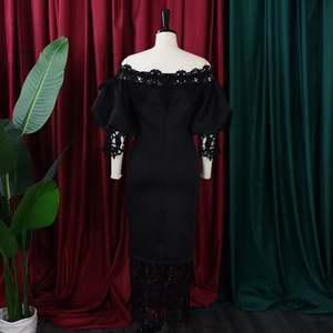 Detail of black off-shoulder dress with puff sleeves and intricate lace trim on the back
