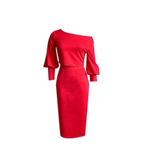 Detalle de top corto rojo con hombros descubiertos y conjunto de falda ajustada