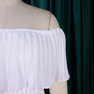 Détail de l'encolure plissée blanche à épaules dénudées sur une robe de soirée élégante