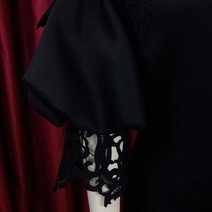 Detailed close-up of elegant black puff sleeves with intricate floral lace stitching