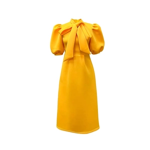 Detail of elegant yellow midi dress with a pussy-bow neck and puff sleeves