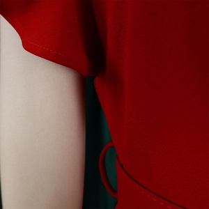 Detail view of red pleated dress showing ruffled sleeve cuff and neat side stitching