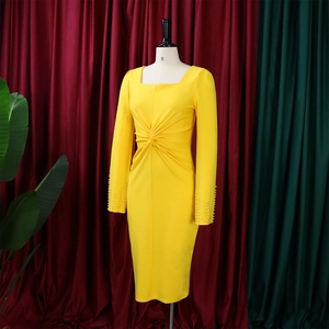 Détail des ornements en perles sur les poignets d'une robe jaune avec nœud à la taille