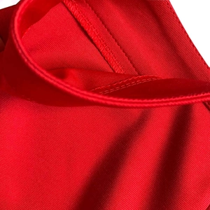 Primer plano del dobladillo reforzado con doble costura en el conjunto de punto rojo