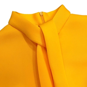 Detail of high collar with decorative tie and invisible back zipper on yellow dress