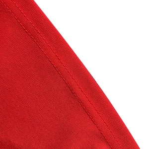 Primer plano de tela de punto roja con textura de malla fina y costuras dobles