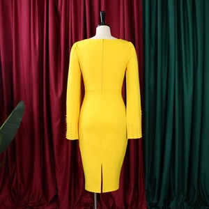 Détail de la robe moulante jaune montrant la fermeture éclair invisible et les poignets