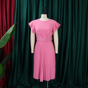 Detail of pink pleated dress featuring a round neck, ruffle sleeves, and matching belted waist