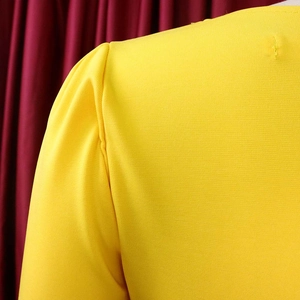 Détail de la robe en tricot jaune avec manches bouffantes et coutures plissées