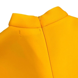 Detail of yellow cocktail dress showing high neckline and invisible back zipper