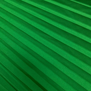 Detailed macro view of vibrant green pleated fabric texture with elegant silky sheen