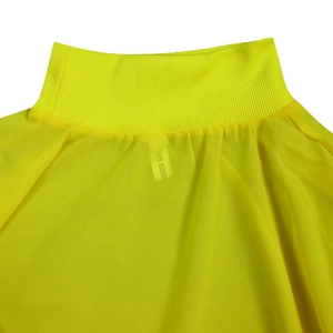 Detail van hoge ribgebreide halslijn en gele chiffon stof op losse zomerse jurk