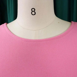 Detail shot of bright pink round neck dress with double-stitched hemline and pleats