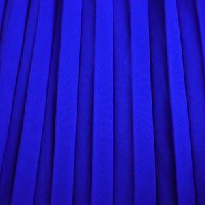 Vue macro d'un tissu plissé vertical bleu roi pour le détail d'une robe de soirée de luxe