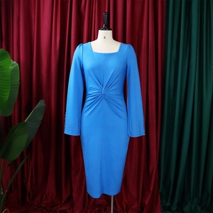 Détail de robe bleue à col carré avec taille nouée et perles délicates aux poignets