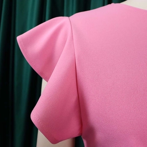 Close-up of pink ruffle cap sleeves and textured fabric on women's summer dress