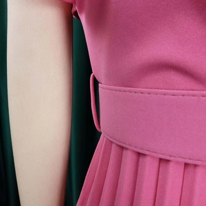 Detail of rose pink pleated dress featuring a matching waist belt and elegant texture