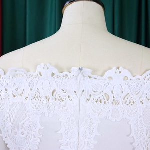 Detailed back view of white lace evening dress showing invisible zipper and floral pattern