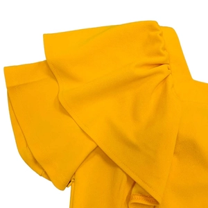 Detail of yellow pleated dress featuring double ruffle sleeves and a hidden side zipper