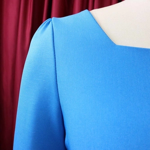 Détail de la robe bleu ciel montrant le col carré et les plis des manches bouffantes