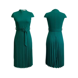 Détail de la robe plissée vert émeraude montrant la ceinture et la boucle carrée