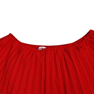 Détail du tissu plissé rouge avec étiquette de lavage sur la robe de soirée