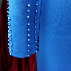 Détail du tissu tricoté bleu royal avec trois rangées de perles lavande décoratives