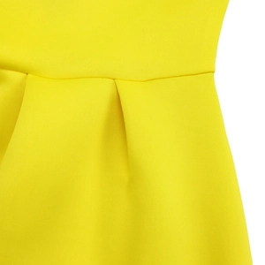 Macro detail of high-quality lemon yellow dress showing pleats and twill fabric texture