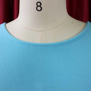 Close-up of the round neckline and textured chiffon fabric on a light blue summer dress