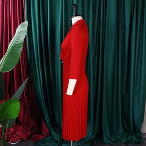 Detailansicht des roten Strickkleids mit Reverskragen und fein gefaltetem Rocksaum