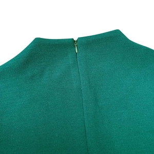 Détail d'une robe vert foncé de qualité avec col montant et fermeture éclair invisible