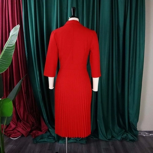 Rückansicht elegantes rotes Plissee-Kleid mit Reverskragen an Schaufensterpuppe auf Samt
