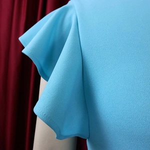 Macro shot of light blue pleated fabric with ruffle sleeve detail and textured finish