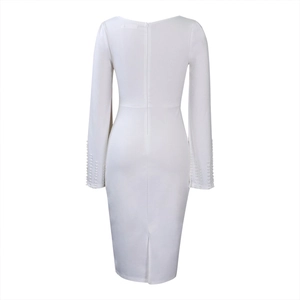 Détail de la robe blanche avec décolleté en V profond, zip invisible et poignets perlés