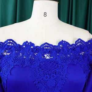 Detail of royal blue off-shoulder dress featuring exquisite floral lace and scalloped neckline