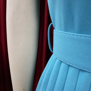 Close-up of light blue pleated dress waist with matching wide belt and chiffon texture