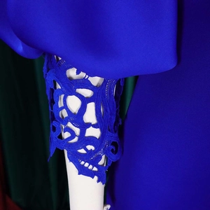 Detailed view of puff sleeves with intricate royal blue lace stitching on satin gown