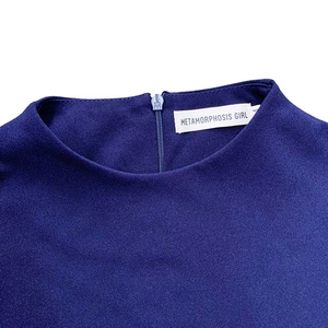 Détail de la robe bleu marine à col rond avec étiquette de marque et zip invisible au dos
