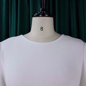 Close-up of a white round neck dress with ruffled sleeves on a professional mannequin