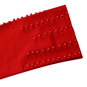 Détail du tissu de robe rouge avec cinq rangées de broderies en perles rouges assorties