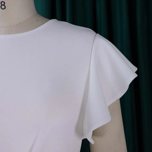 Detailed view of elegant white ruffle flutter sleeves and round neckline on a summer dress