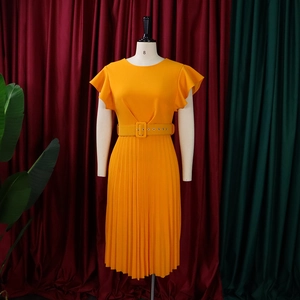 Detail of orange pleated dress featuring ruffled cap sleeves and matching buckled belt