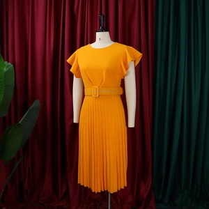 Detail of orange pleated dress featuring ruffle sleeves, crew neck, and matching waist belt