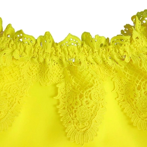 Close-up of vibrant yellow off-shoulder dress with intricate crochet lace trim detailing