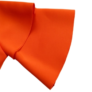 Detail view of the vibrant orange tiered ruffle sleeves and fine woven fabric texture