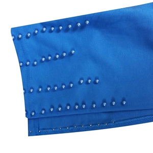 Gros plan sur tissu bleu foncé avec rangées de perles assorties et rivets métalliques