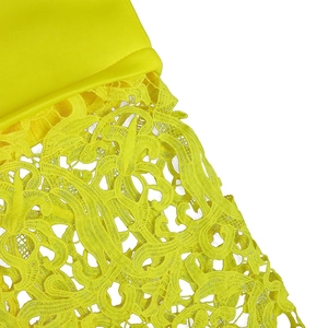 Detail of yellow lace embroidery and smooth satin fabric on a plus size evening dress
