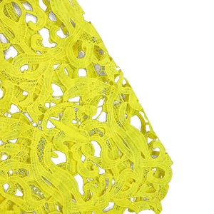 Detaillierte Nahaufnahme von neon-gelbem Spitzenstoff mit eleganten Blumenrankenmustern